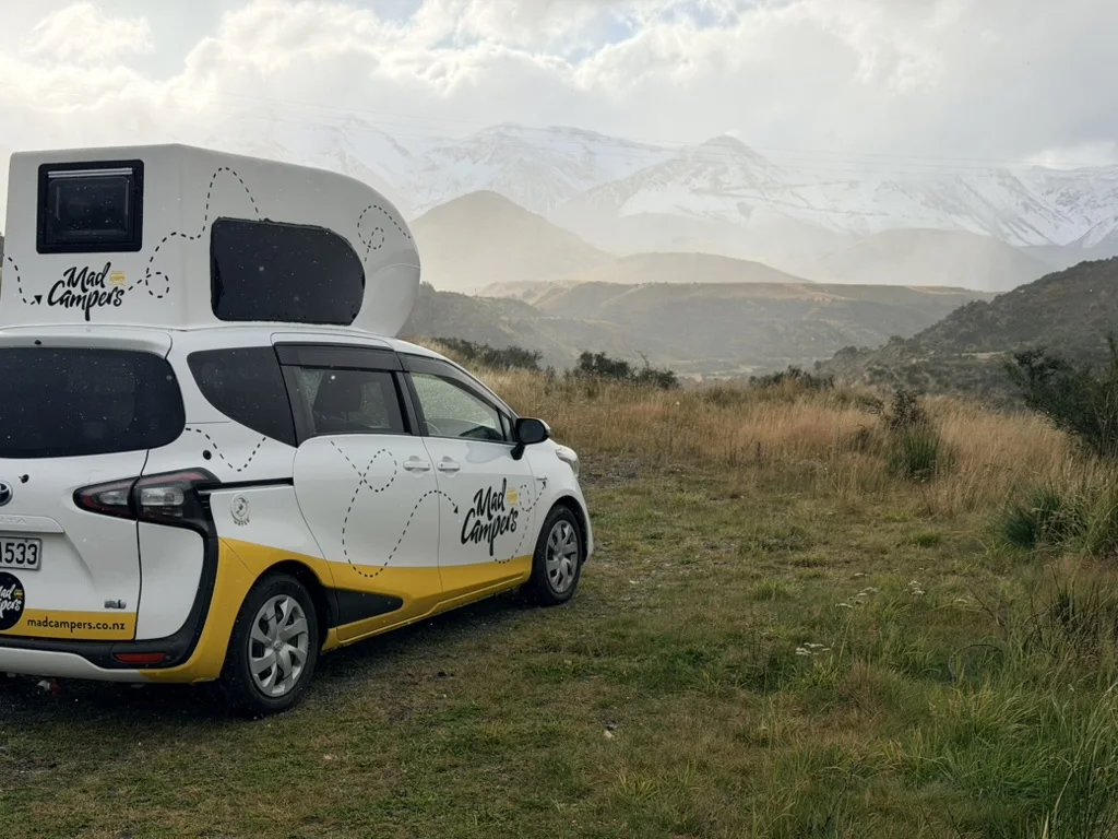 Kompakter Camper vor schneebedeckten Bergen